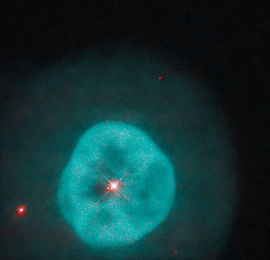 Bright turquoise nebula with a fainter teal halo and a bright red star at its center, with a few other, smaller red stars in the background.